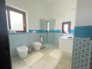a bathroom with two toilets and a tub and a sink at Villa Rosati B & B - Home Restaurant in Capoterra +7 photos