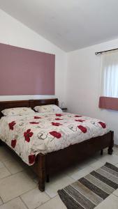 a bedroom with a bed with red flowers on it at Villa Rosati B & B - Home Restaurant in Capoterra