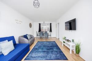 a living room with a blue couch and a table at Ebony Door Serviced Accommodation Barking Riverside in Barking