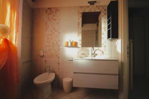 ein kleines Bad mit einem Waschbecken und einem WC in der Unterkunft Kia Orana Guesthouse in Livorno