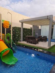 una piscina con tobogán y un parque infantil en شاليهات بالي ان الفندقية, en Yeda
