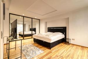una camera da letto con un letto grande e uno specchio di Luxurious 3 Bedroom Apartment in Herastrau a Bucarest Altre 53 foto