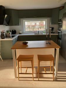 uma cozinha com uma mesa de madeira e 2 cadeiras em Långasand em Heberg