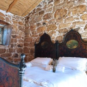 um quarto com uma cama numa parede de pedra em holiday home su Niberalzu em Monti