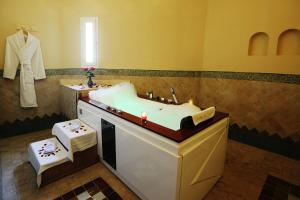 a bathroom with a sink and a bath tub at Berbère Palace in Ouarzazate