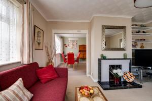 ein Wohnzimmer mit einem roten Sofa und einem Kamin in der Unterkunft 3 Bed Renovated Bungalow - 3 car or RV pkg - Garden in Southampton