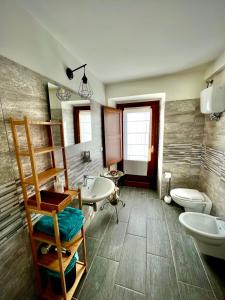 uma casa de banho com um lavatório, um WC e um lavatório. em Il Bivacco del Duomo em LʼAquila