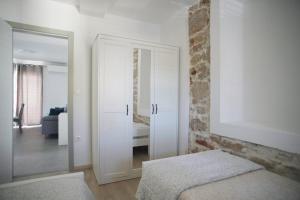 sypialnia z białą szafką i lustrem w obiekcie Apartman Ferara w mieście Tribunj