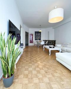 a living room with white furniture and a potted plant at Cosy two bedroom apartment in Brussels in Brussels