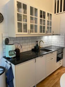 a kitchen with white cabinets and a black counter top at Stuga i Vemdalen in Vemdalen