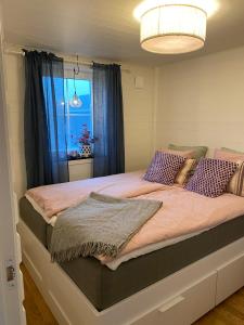 a bedroom with a large bed with purple pillows at Stuga i Vemdalen in Vemdalen
