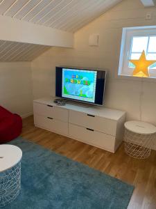 a living room with a television on a white dresser at Stuga i Vemdalen in Vemdalen