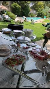 una mesa de cristal con platos de comida. en Muco Guest House, en Johannesburgo