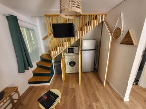 um quarto com uma escada com um micro-ondas e um frigorífico em Ô Vert-Tige : Piscine Jardin Pétanque Proche centre ville em Entre-Deux