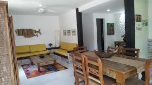 - une salle à manger avec une table, des chaises et un canapé dans l'établissement Casa em Cond Geriba 400mt Praia com Espaço Gourmet, à Búzios