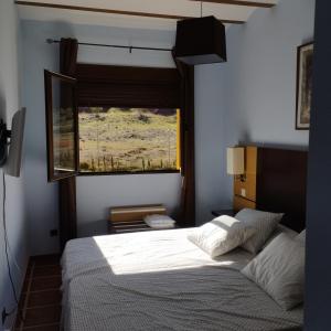 a bedroom with a bed and a window at Finca Cortés in Alcaraz
