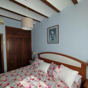 1 dormitorio con 1 cama con colcha de flores en Finca Cortés, en Alcaraz