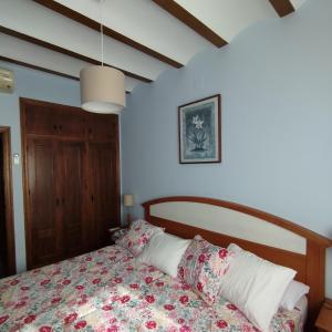 a bedroom with a bed with a floral bedspread at Finca Cortés in Alcaraz +25 photos