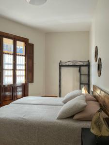 een witte slaapkamer met een groot bed met kussens bij Apartamento Palacio de Las Sevillanas in Haro