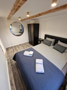 a bedroom with a large bed with two towels on it at R&J Guesthouse Apartment in Grindavík