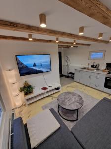 a large living room with a tv on a wall at R&J Guesthouse Apartment in Grindavík