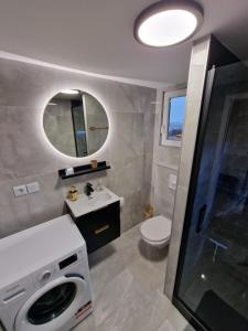 a bathroom with a sink and a washing machine at R&J Guesthouse Apartment in Grindavík