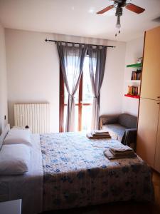 a bedroom with a bed and a window with a couch at SUITE TRAVEL HOME in Modena