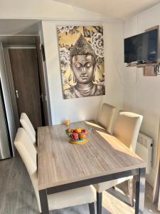 a dining room table with a bowl of fruit on it at Mobile home Zen Siblu Fréjus in Fréjus