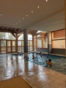 eine Gruppe von Personen, die in einem Schwimmbad schwimmen in der Unterkunft La Plagne-les Coches vue Mont Blanc 6 pers piscine sauna in Les Coches