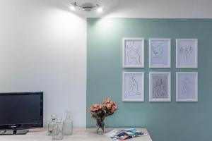 a room with drawings of people on a wall at Terzo Campanello - Terrazza nel Centro Storico in Lecce