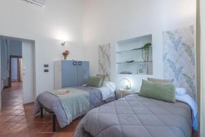 a bedroom with two beds and a table in it at Terzo Campanello - Terrazza nel Centro Storico in Lecce