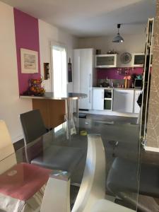 eine Küche mit einem Glastisch und weißen Schränken in der Unterkunft Villa Rose Suite et chambres in Montpellier