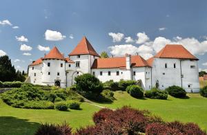um grande castelo branco com telhados vermelhos num campo verde em Holiday Home Sviba em Varaždinske Toplice