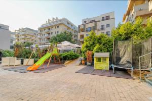 un parco giochi con scivolo arancione e scivolo giallo di Luxurious 3 Bedroom Apartment in Herastrau a Bucarest