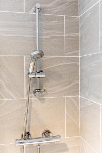 a shower with a chrome shower head in a bathroom at 3 bedroom home sleeps 5 close to Chester City Centre welcomes couples, small groups, families and contractors in Chester