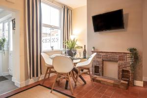 a living room with a table and chairs and a fireplace at 3 bedroom home sleeps 5 close to Chester City Centre welcomes couples, small groups, families and contractors in Chester