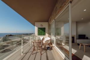 d'un balcon avec une table et des chaises donnant sur l'océan. dans l'établissement Modern Grand Seaside & Seaview by Vacationy, à Matosinhos
