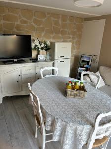uma sala de estar com uma mesa com cadeiras e uma televisão em Location Bonnieux Provence em Bonnieux