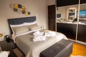 1 dormitorio con 1 cama con toallas en "Elegance" Central Luxury Apartment Piraeus en Piraeus