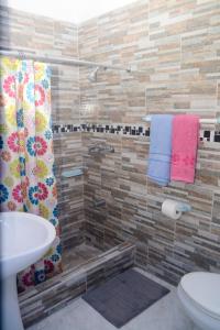 W łazience znajduje się prysznic, toaleta i umywalka. w obiekcie Robin Hood Guest House w mieście Port Antonio