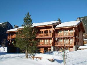 een groot houten gebouw met sneeuw op de grond bij Appartement Pralognan-la-Vanoise, 3 pièces, 6 personnes - FR-1-464-67 in Pralognan-la-Vanoise