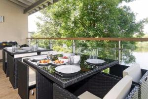 a table with plates of food on a patio at Cotswolds Lake side home with luxury spa Swallows Nest,Lower Mill Estate, Lakeside home/spa in Somerford Keynes