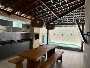 a large kitchen with a wooden table and benches at Casa Praia dos Carneiros in Tamandaré