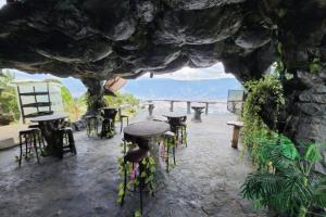a group of tables and stools sitting in a cave at Cabaña Parque Arvi vista panorámica in Medellín
