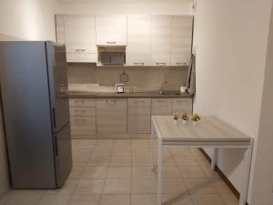 a kitchen with a table and a refrigerator at Casa Sole in Vimodrone