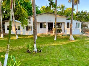 una casa con palmeras delante en Casa Mahi, en El Progreso