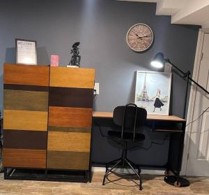 un bureau avec une chaise et un réveil sur un mur dans l'établissement GuestHouse In Clifton NJ, à Clifton