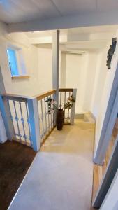 a stairway with a vase of flowers in a room at SPINDRIFT is A Beautiful Newly Refurbished THREE BEDROOM Private Family House located on the OLD HARBOUR and the COASTAL PATH in the Heart of Beautiful POLPERRO in Polperro