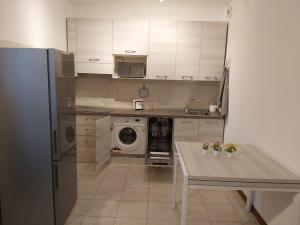 a kitchen with a table and a washing machine at Casa Sole in Vimodrone