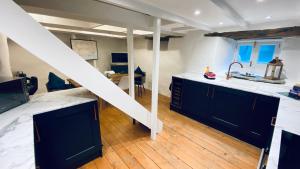 a kitchen with blue cabinets and a white counter top at SPINDRIFT is A Beautiful Newly Refurbished THREE BEDROOM Private Family House located on the OLD HARBOUR and the COASTAL PATH in the Heart of Beautiful POLPERRO in Polperro
